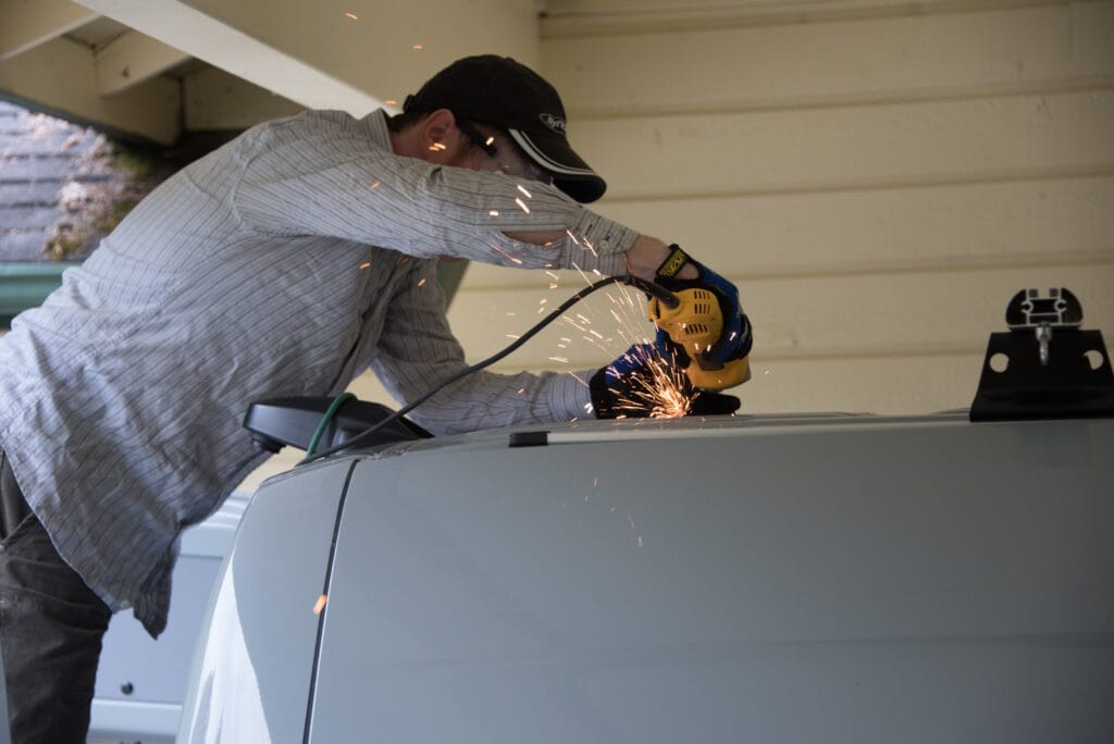 Using an angle grinder to cut out between the corner holes. Slipping is not an option.