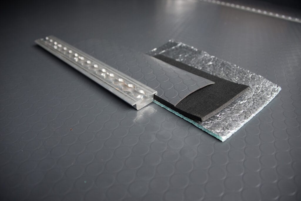 The three layers of flooring we added, held in place with flanged l-track