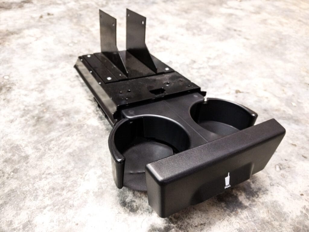 The removed cup holder showing how the bolts mount