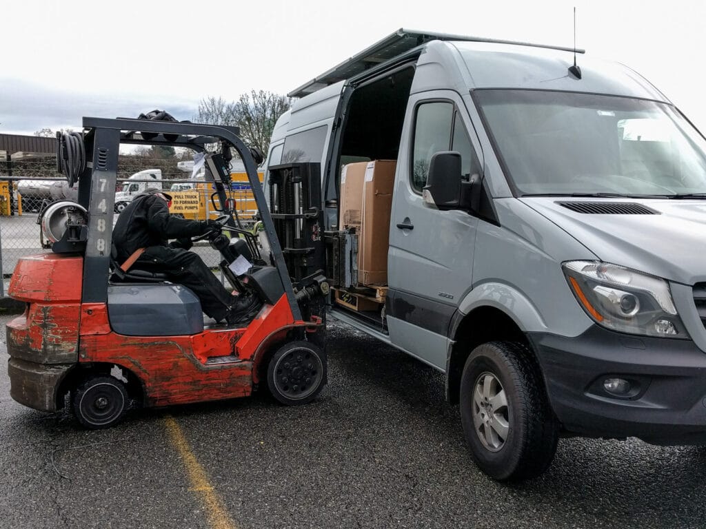Seats being put into the van by a forklift truck