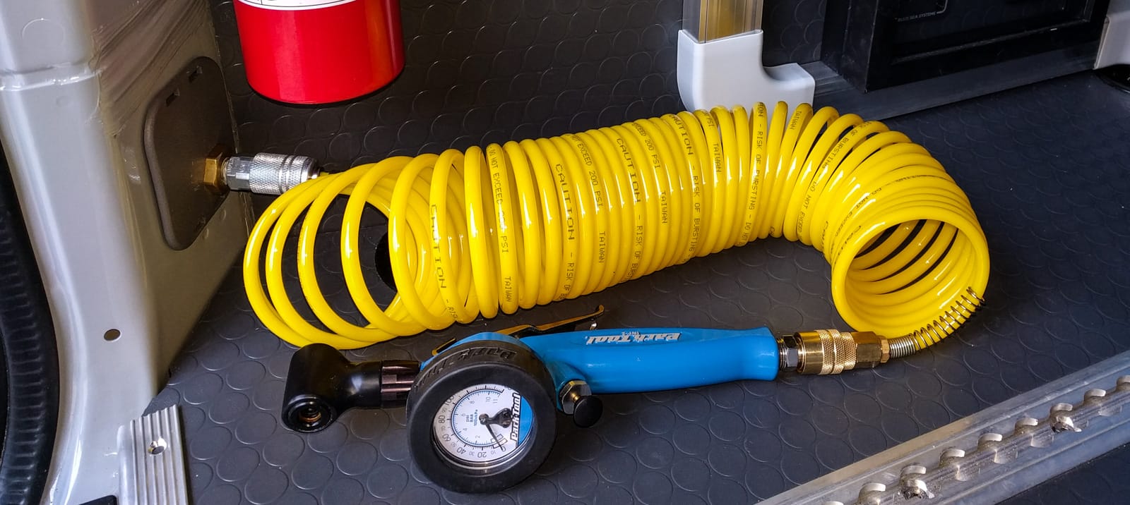 Tire inflator inside back door pillar
