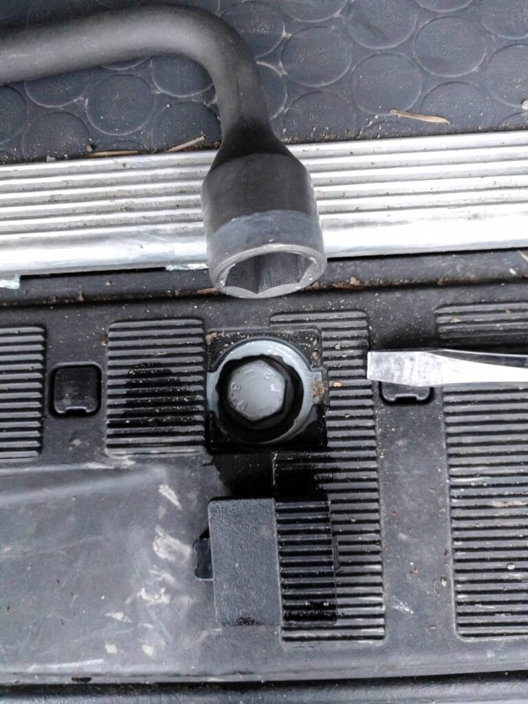 Using the wheel lug wrench to lower the spare tire holder