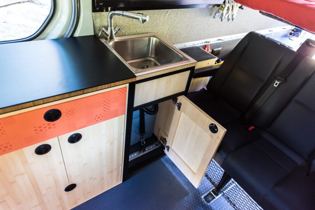 Sink cabinet with grey water tank strapped in underneath