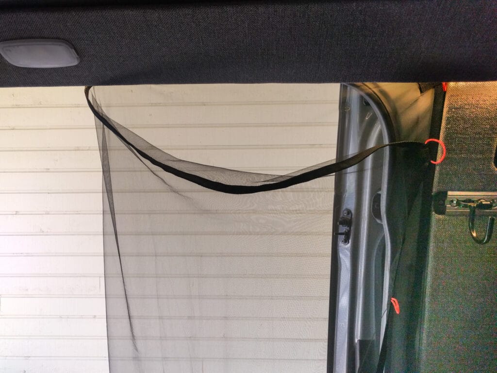 Mosquito net folded back to expose door opening
