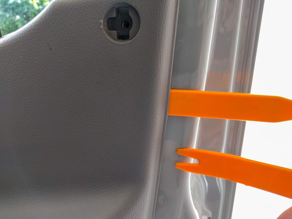 Door panel removal - lever the plastic panel away from the metal door