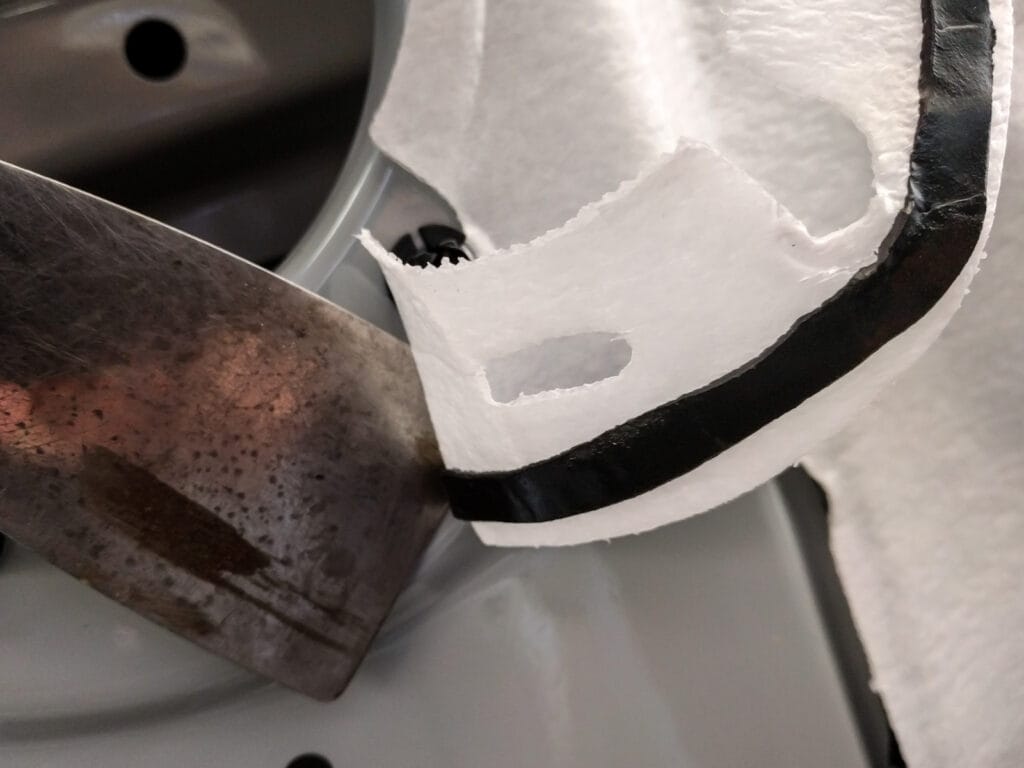 Pull the white material away from the door. Use a scraper to make sure the black sticky stuff stays in one piece so you can re-use it