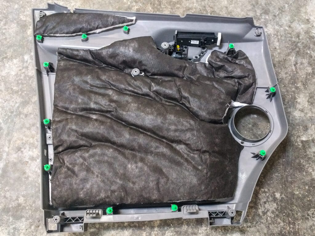 Add sound deadener and Thinsulate to the inside of the door panel, leaving the green clips and two screw locations in the handle area clear