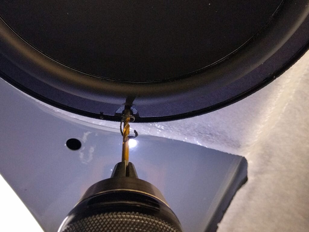 Mount the speaker in place, then carefully drill holes in the spacer and attach the speaker screws
