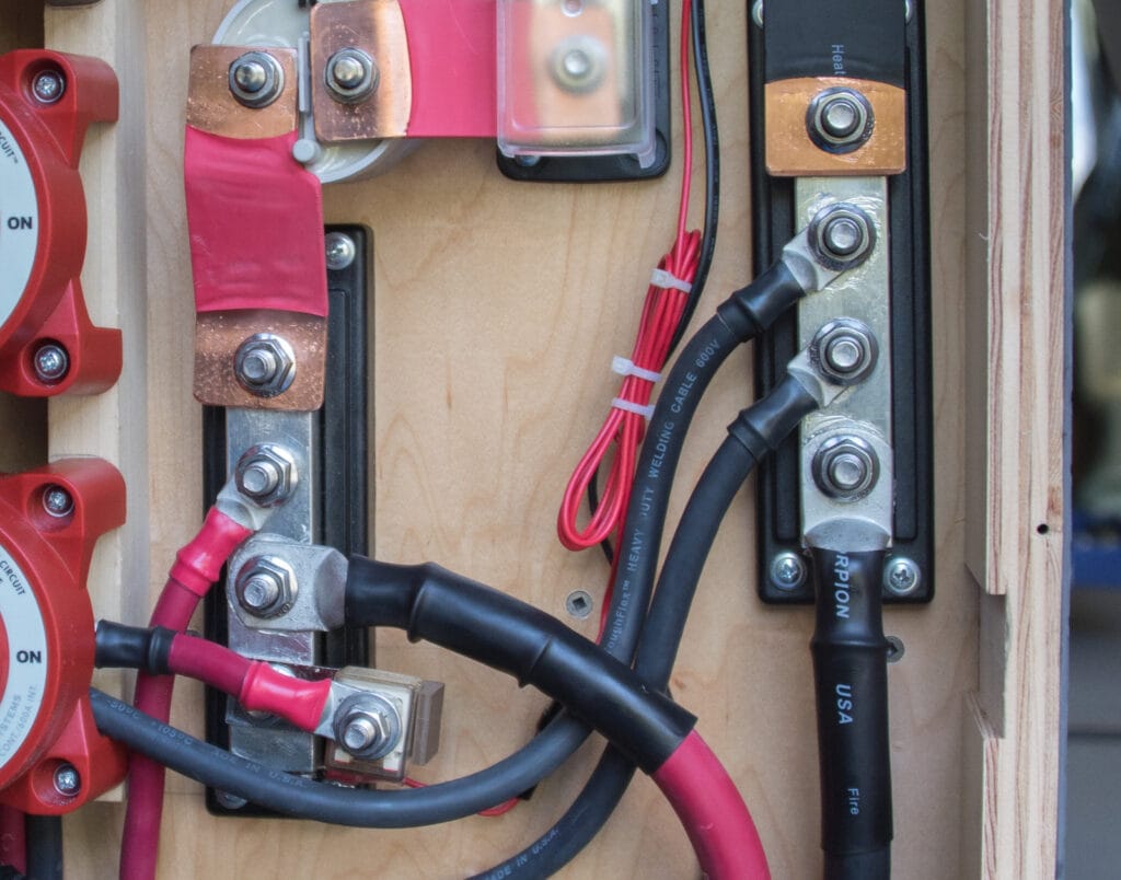 Positive and negative bus bars with 4/0 and 2 AWG cables attached