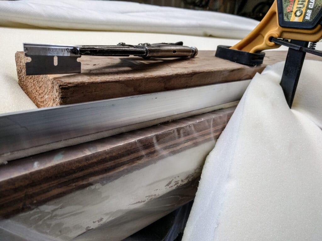 Mattress foam clamped and being cut