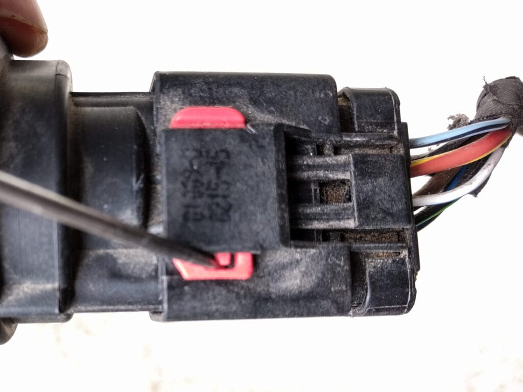 Slide the red clip to the side after releasing the tab