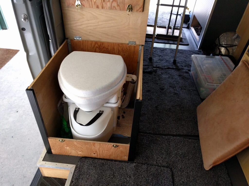 The toilet in place in the cabinet