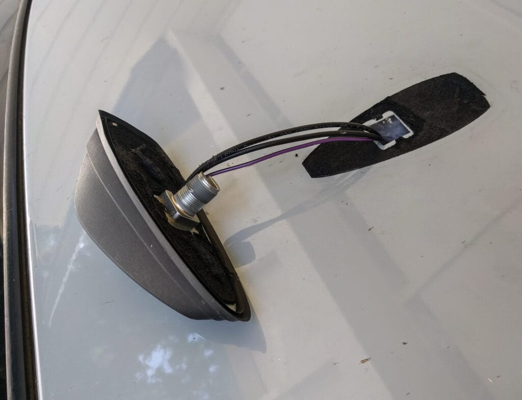 The antenna after the nut is removed from its fixing bolt - you'll have to work a blade or string under the base to remove all the black sticky