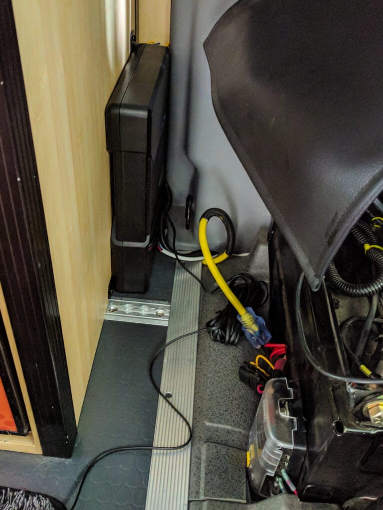 Subwoofer attached to fridge cabinet behind driver's seat