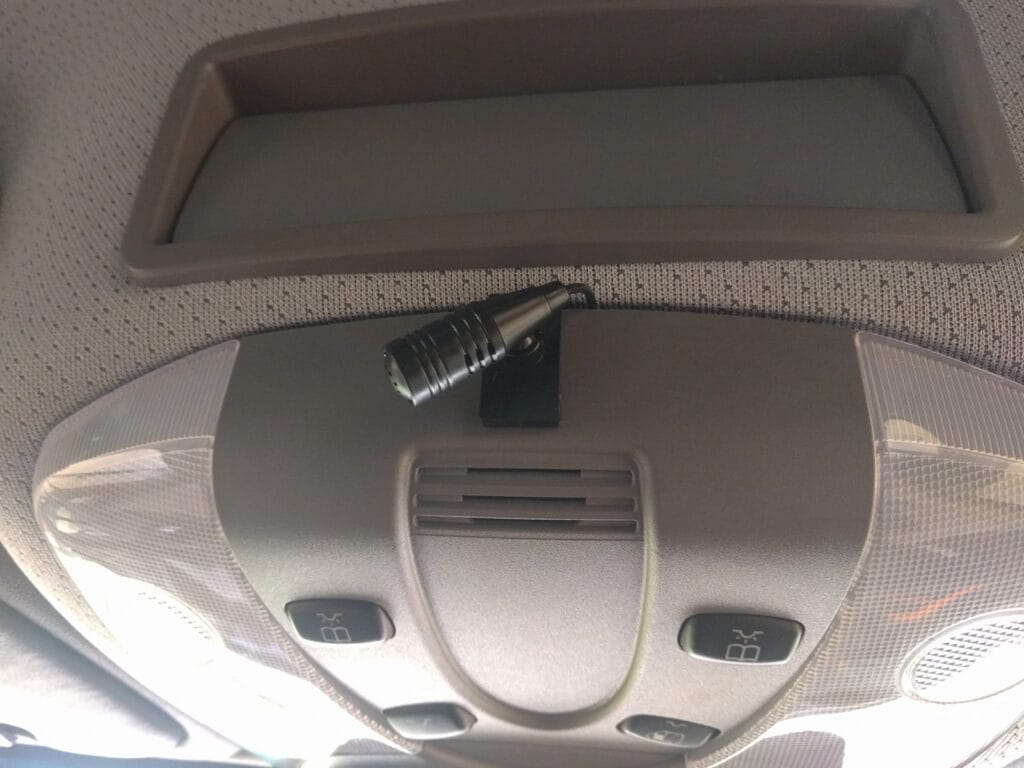 We clipped the Sony microphone to the outside of the overhead center console, but you could remove the stock microphone and mount it inside - you can see the grille where the stock microphone lives just below where we clipped the Sony mic in place.