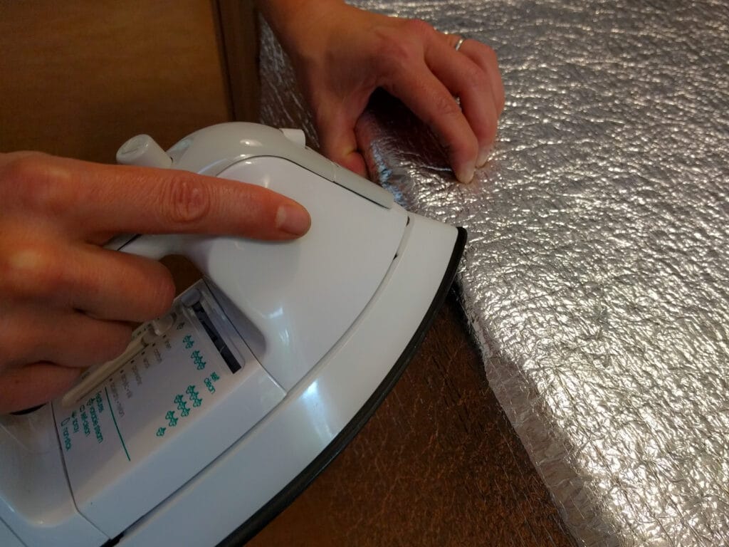 Ironing Low-E along the edge of a kitchen countertop to create a fold line.